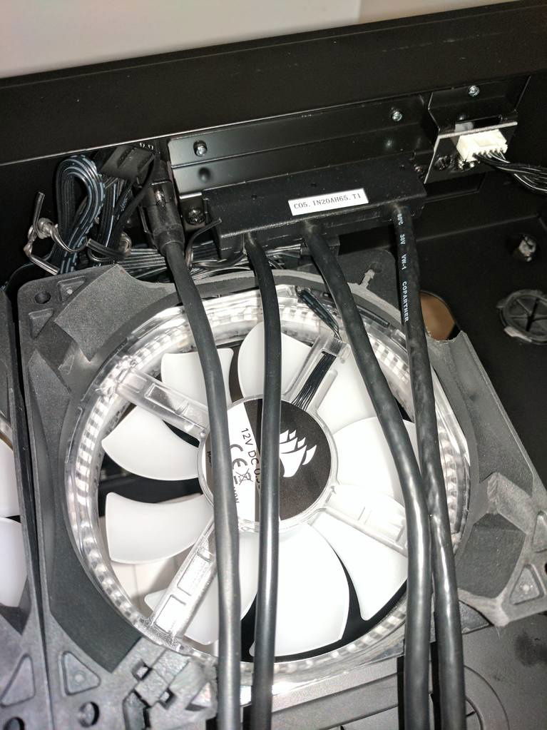 You can see the front panel cables and how they obstruct the fans and radiator. I had to make a cutout of the fan spaces to route the cables. Some folks have just bent the cables, but I wasn't comfortable doing that.