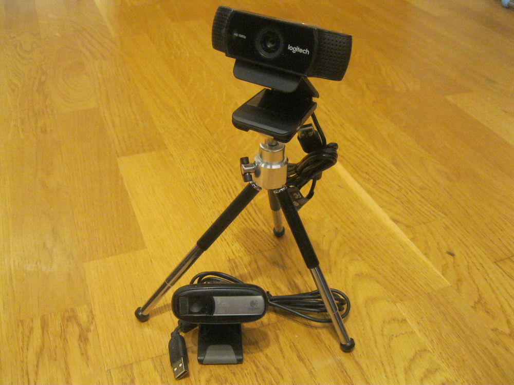 New webcam (C922) with it's tripod next to old webcam (C170).