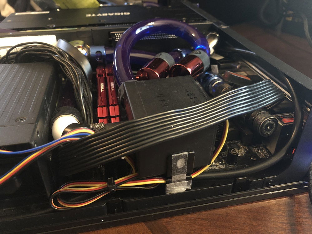 Phobya 220 DC pump mounted using a custom mount i made with vibration dampening. to the right is a fill port made of a koolance male QDC with a alphacool ball valve behind it in case the QDC leaks.