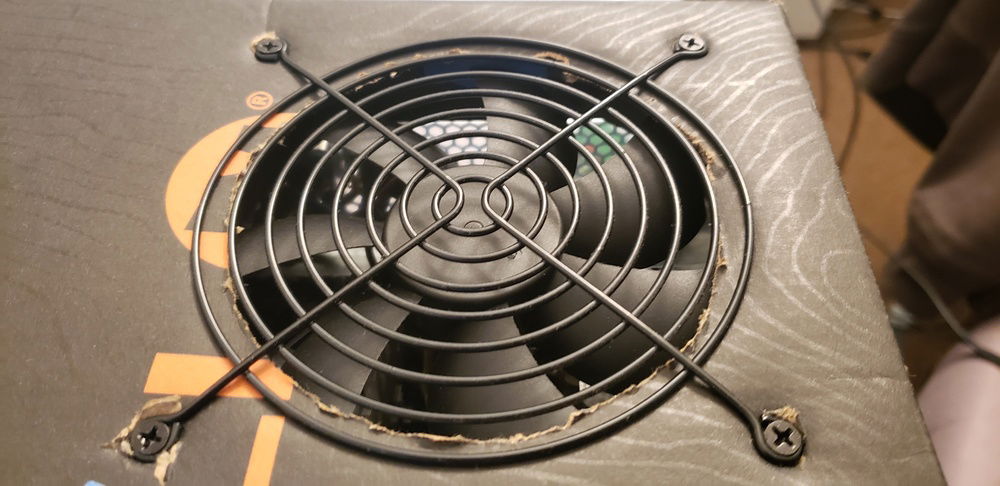 PSU held in place by the metal grate taken off then screwed through the top of the box