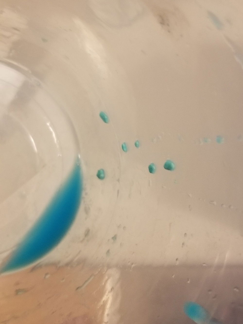 After my first squeeze bottle was in this was enough fluid to leave the pump on and it circulate and all I had to do was top off the res. I just so happened to take a look at the bottom of the gpu and noticed there was some small white granular stuff building up in the gpu block fins at but at this point there wasnt a whole lot of it. So I took a close look at my remaining fluid mix and saw the chunks on the bottom that you can see in the previous picture.