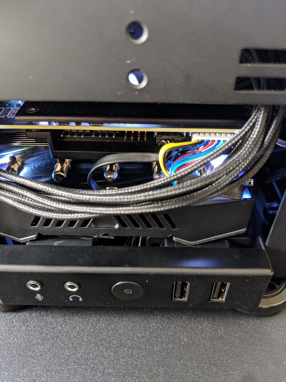 The GPU's fan shroud resting on top of the NCase M1's front audio and USB I/O.