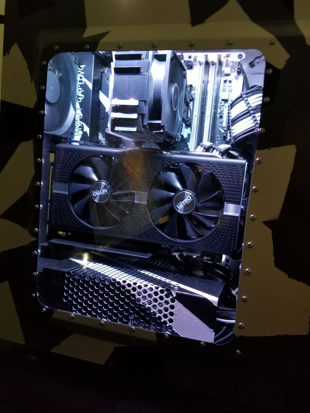 The Sapphire Nitro+ RX 570 can be seen here through the custom case window, supported by a Cooler Master vertical GPU bracket that required the rear expansion port dividers to be dremelled off.
