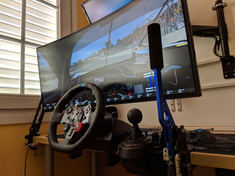 Simracing with custom DIY handbrake and monitor arm extended.