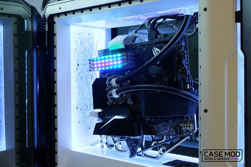 Motherboard is suspended in the center of the case, caught in a chrome web..