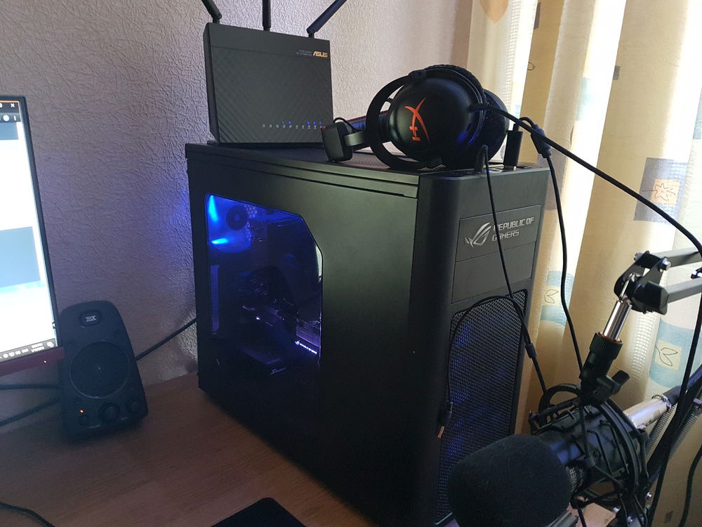 External view of my rig. Asus RT-AC66U gigabit router on top. Primary network access point for my SteamLink setup and Samsung 4K TV via 5Ghz Wi-fi. Neewer NW-700 condenser microphone on a boom arm is also displayed.
