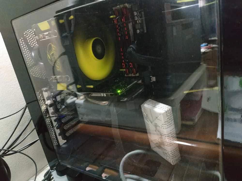 My PC. Sorry about the reflections. 
I improvised a GPU stand from a piece of wood wrapped in paper.
