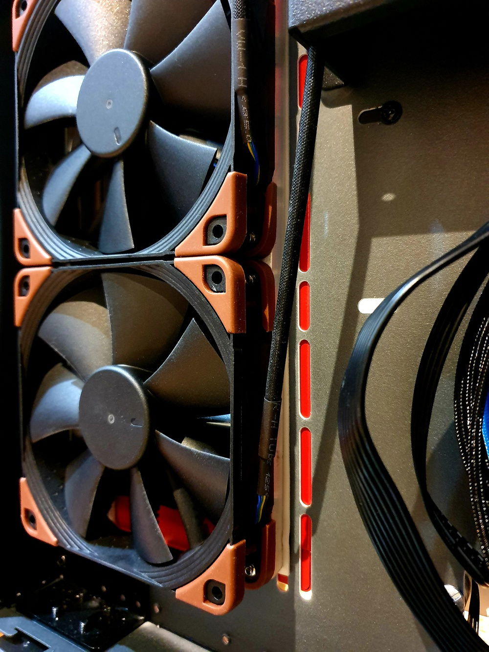 Close up of the fans screwed to custom brackets which are attached to the case with 2 sided adhesive tape