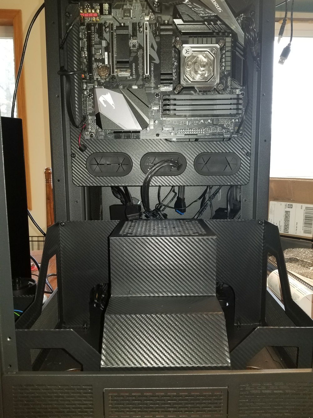 Hard drive cage and side trims installed.  Vinyl wrapping on the trim hides the holes I drilled for mounting the pump, so it worked out well.  Here's hoping my calculations are correct and that by the time I get the pass-through for the water lines wrapped that the lines......line up.