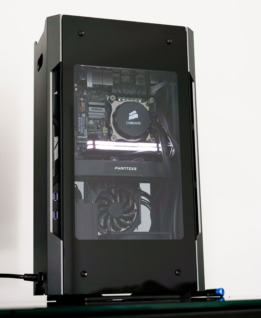 Tops'l. This is a home office build using the Phanteks Evolv Shift with tempered glass side panels. It's a mostly monochrome build featuring a lot of Corsair black.
