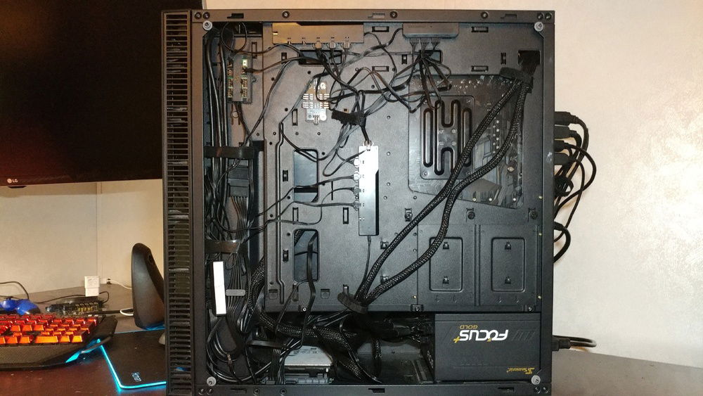 Since I see some people like the back of the PC view for some reason, here it is. Not the best cable management I've done, but not the worst either, especially considering I'm wiring 10 RGB devices back there and the back panel is glass too so it has to be uniform, not in a bundle. I ran out of cable ties either way.
