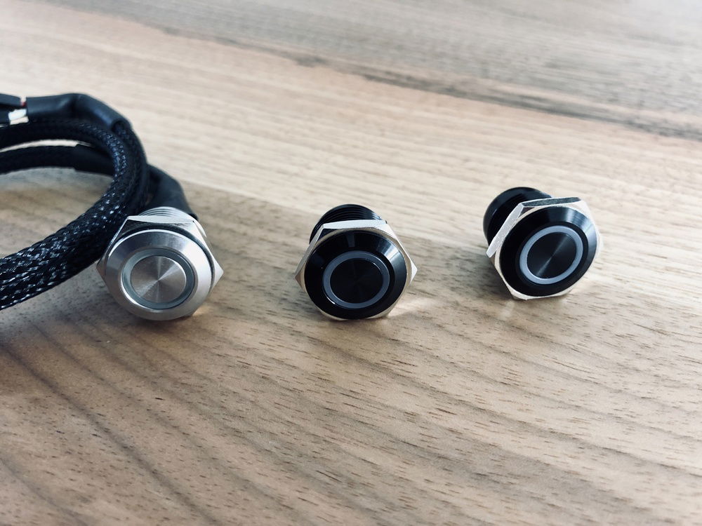 Replacement switches. Original switch (left), black with white LED (right) and black with RGB led (middle)