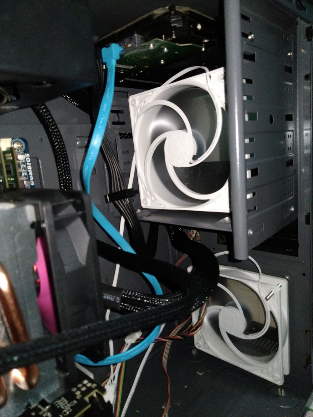The intake fans were mounted at the optical drive bay and below, adjacent to the graphics card. The upper fan is used to provide airflow between the PSU and CPU, in addition to cool the former. Meanwhile, the fan below helps the graphics card stay cool.