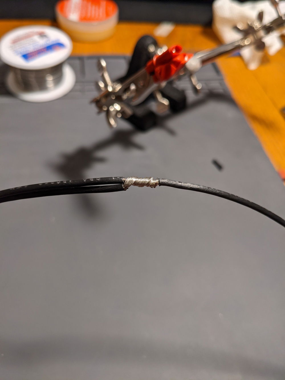 I would then untwist the wire and flatten it out a bit, and then wrap it tightly around the main wire. I'm fairly new to soldering, but I do know that it's important to have good mechanical connection before the solder, rather than relying on the solder to make the the connection strong.