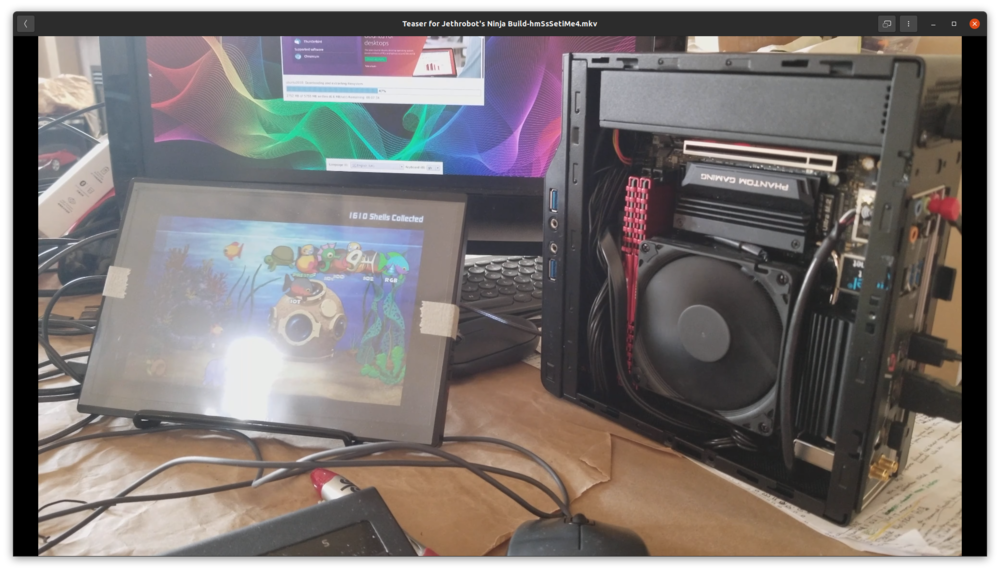 with Chromax fan. Running Insaniquarium(!). Keyboard (K380) and mouse (M350) set is in between screen and PC.