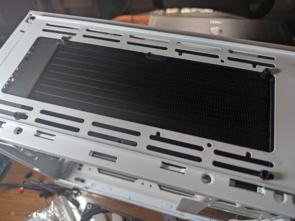 The radiator mounted. I moved it to the side towards the glass panel to clear the power cable housing on the other side.

This also created space on the other side where I could hide/route my cabling.