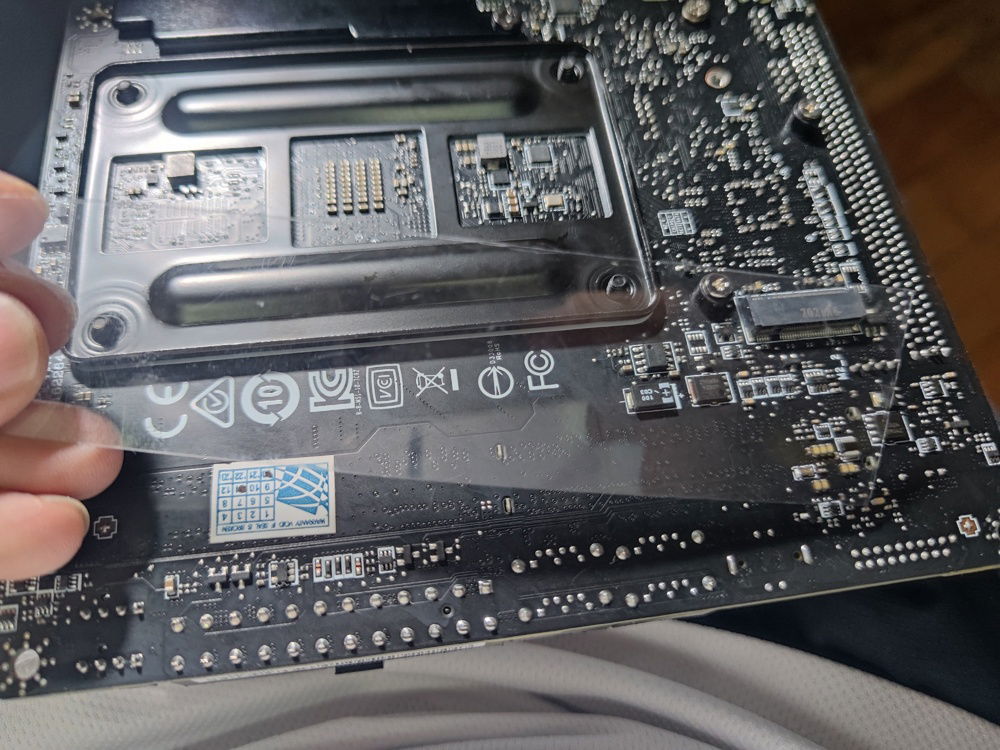 Plastic on motherboard rear for additional insulation for cables.