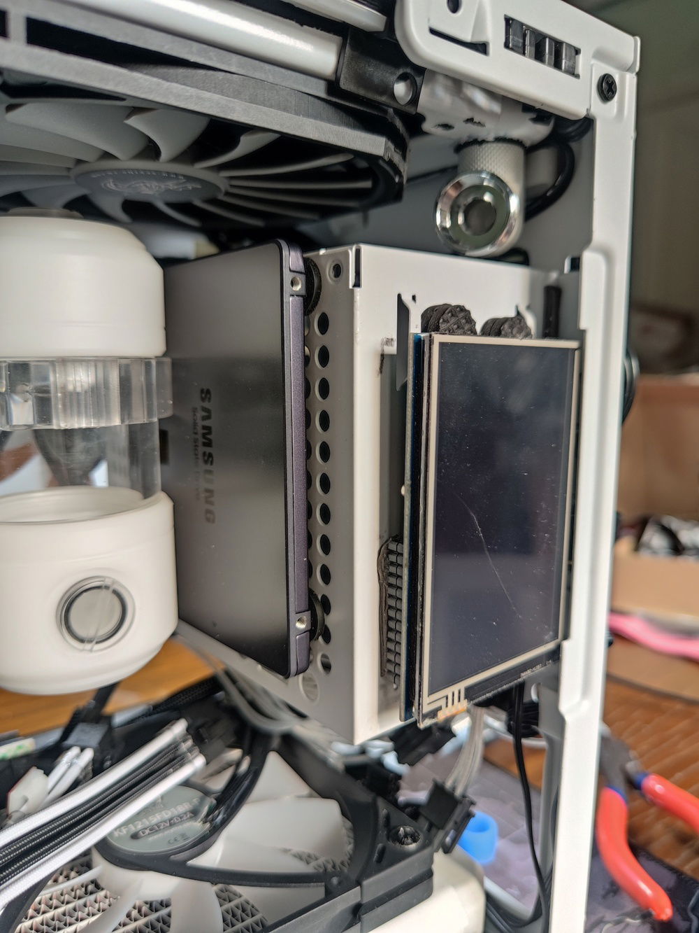 The whole build revolved around gaining enough clearance to fit all of the components and to some extent, ease access for future maintenance.

In this pic can be seen the cut made into the frame of the fan to clear the fitting and tube.