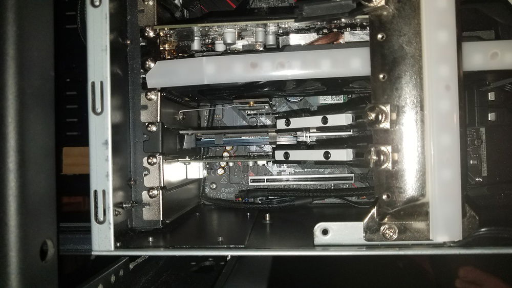 A wiper insert bolted to a slot blank keeps the NVMe SSD in the x1 slot away from the GPU fans. The x4 PCIe adapter has a short M.2 slot so a washer was added behind the PCB of the SSD to stop it from bending over the EK heatsink straps.