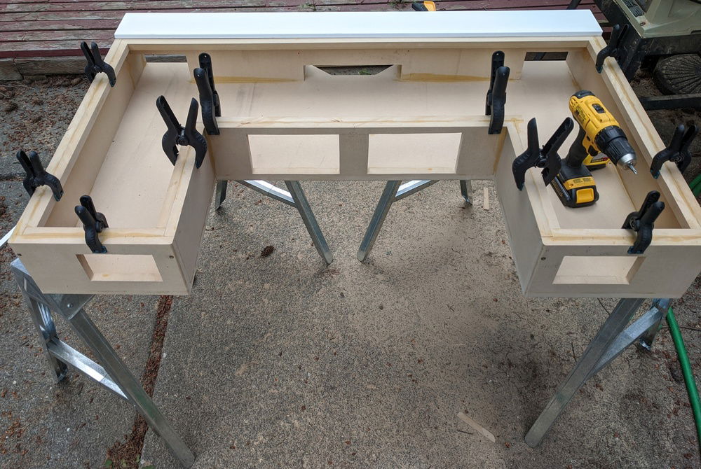 Attaching the trim to hide the LED strips with wood glue and clamps.