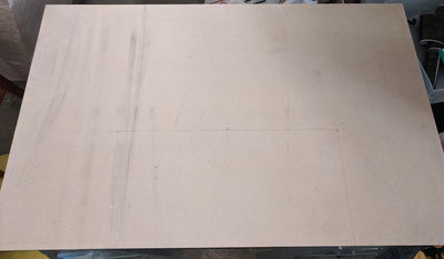 Plain sheet of 3/4" MDF already cut to be the correct overall size for the desk, with markings based on my CAD drawings.