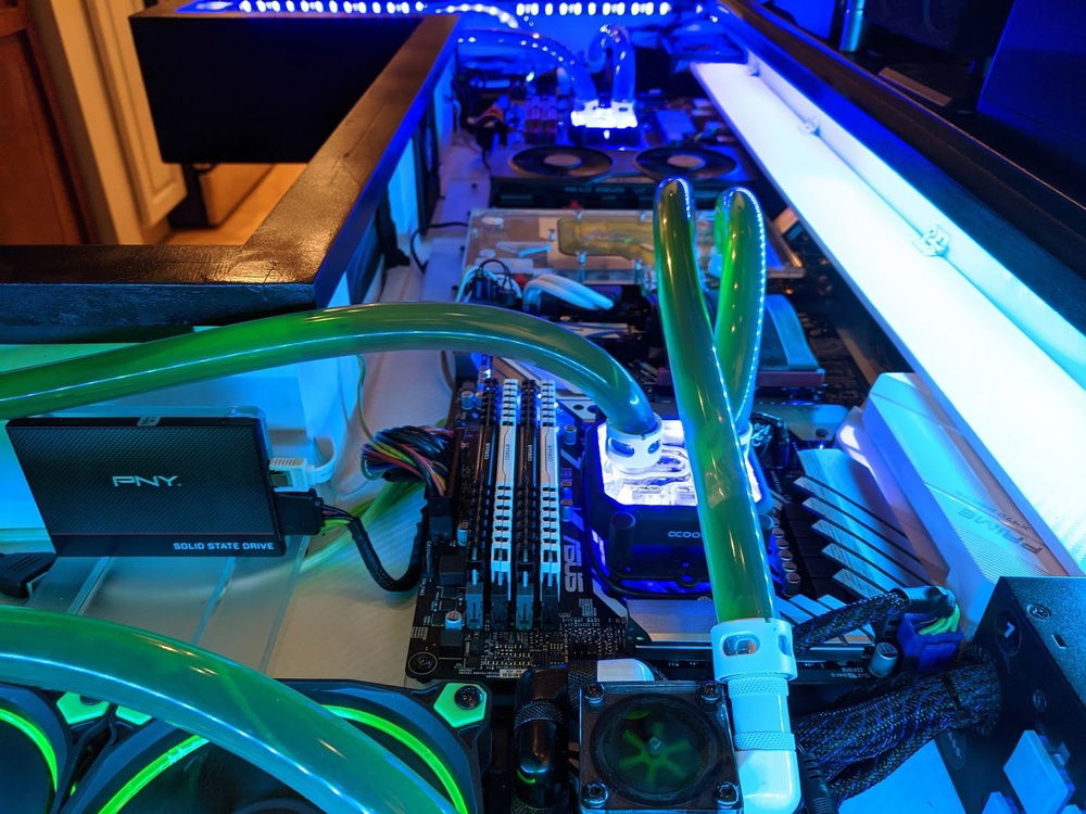 The whole inside of the desk has a white carbon fiber wrap that looks really cool in person but washes out extremely easily on camera.  The hinged flap on the right side of this image is for covering the cables coming in from the filtered rear port.  Accessing the motherboard or GPU ports is as simple as flipping up the flap.  After I lift off the giant glass sheet of course :V