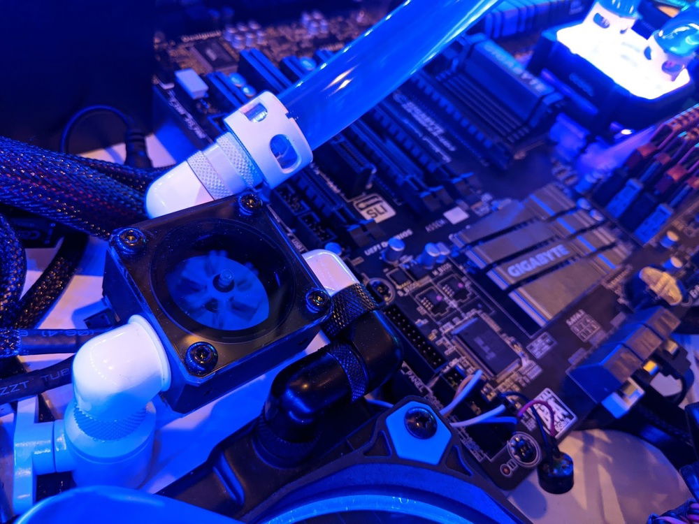 The flow meters are really cool, and also function as T junctions for draining the loop.  This branches off to a ball valve which has an extender on the opposite side exactly the right size to go through a hole in the desk and end up flush with the bottom.  It's rock solid and the port on the bottom is almost completely invisible.