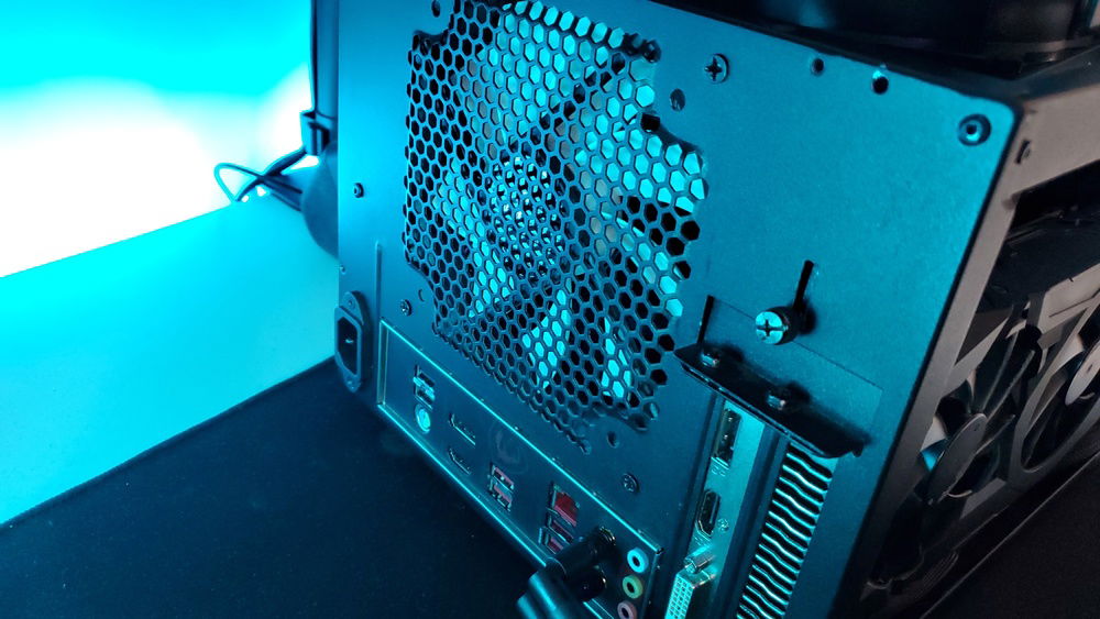 Rear view of pc while off, shows io and gpu outputs and my half-broken wifi antennas from putting the pc in a suitcase and accidentally clipping them on the side of the case. You can't see it but one got over-extended backwards and one always pops off at the hinge.