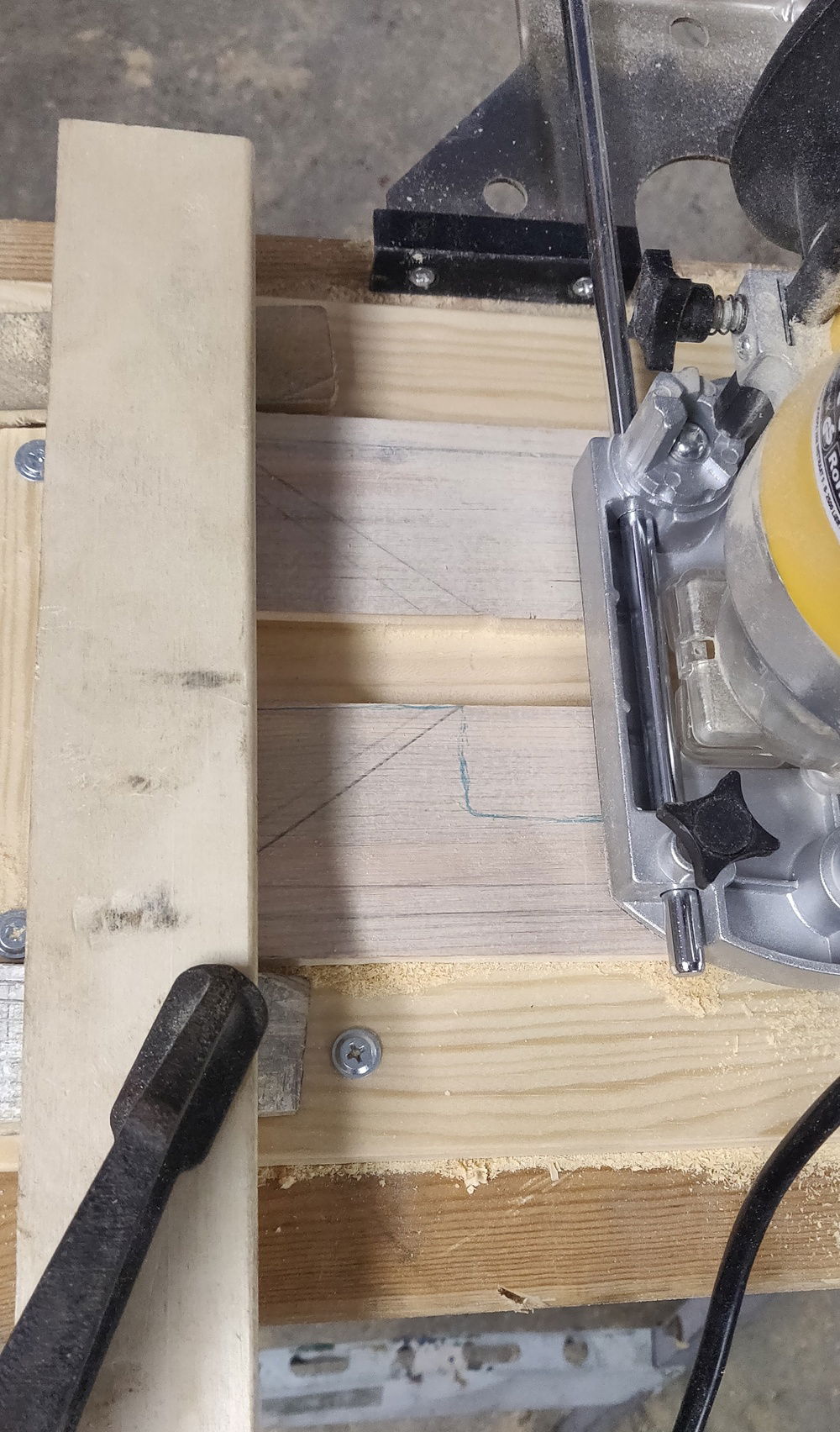 Wood piece clamped across to prevent me from going too far. Clamped high enough to allow the router attachment to pass under. And yeah I drilled some wood pieces to the stand to keep it stuck without having to clamp the wood itself. Definitely not the right way to use the tool but as long as it works eh?