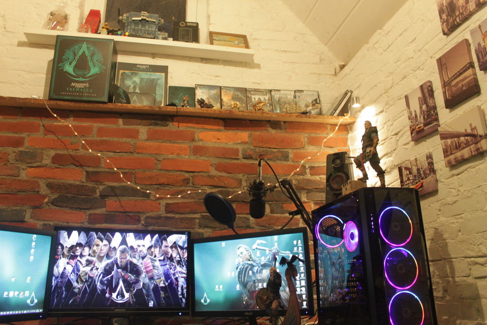 Gaming place with the Assassins Creed collection above