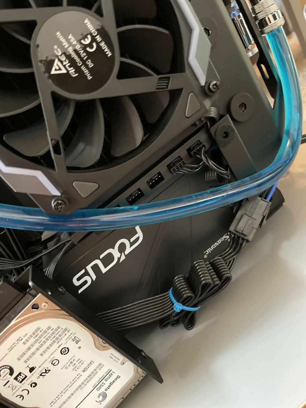 The RGB and fan controller box from Antec Prizm Cooling Matrix is taped onto the bottom face of the radiator. There is a 1-to-5 DRGB splitter connected too, making more headers available.