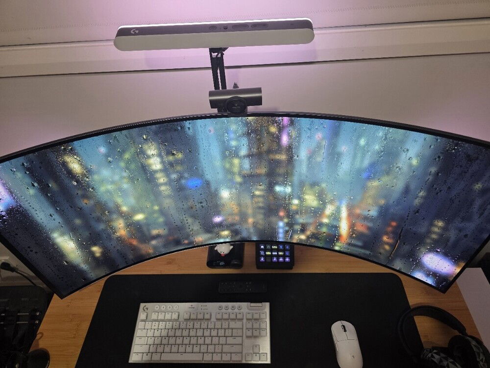 Right in the middle is a 45" ultrawide LG OLED, mounted on an arm. 
My own personal IMAX. I play a lot of first person shooters and the sense of immersion in a pitch black room is hard to describe.

The keyboard is a Logitech G915X TKL. Brushed aluminium and white mechanical keys tie the silver and white theme, and it's very minimal. This is a gaming PC, there's not much spreadsheeting going on here.

The mouse is a Logitech G Pro X Superlight. It feels like I'm using motion controls. It's fast and responsive and matches the keyboard. The only drawback of these two peripherals is that I have the original versions of each - that means Micro-USB charging. I can't justify spending hundreds of dollars just yet on replacing my KB+M just because they're the only non USB-C devices left in my house. *side eye*