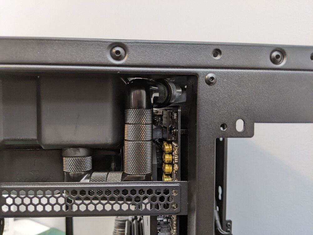 All the way to the back of the case (bottom of mobo side in this pic). This would also apply to a reservoir in the back.