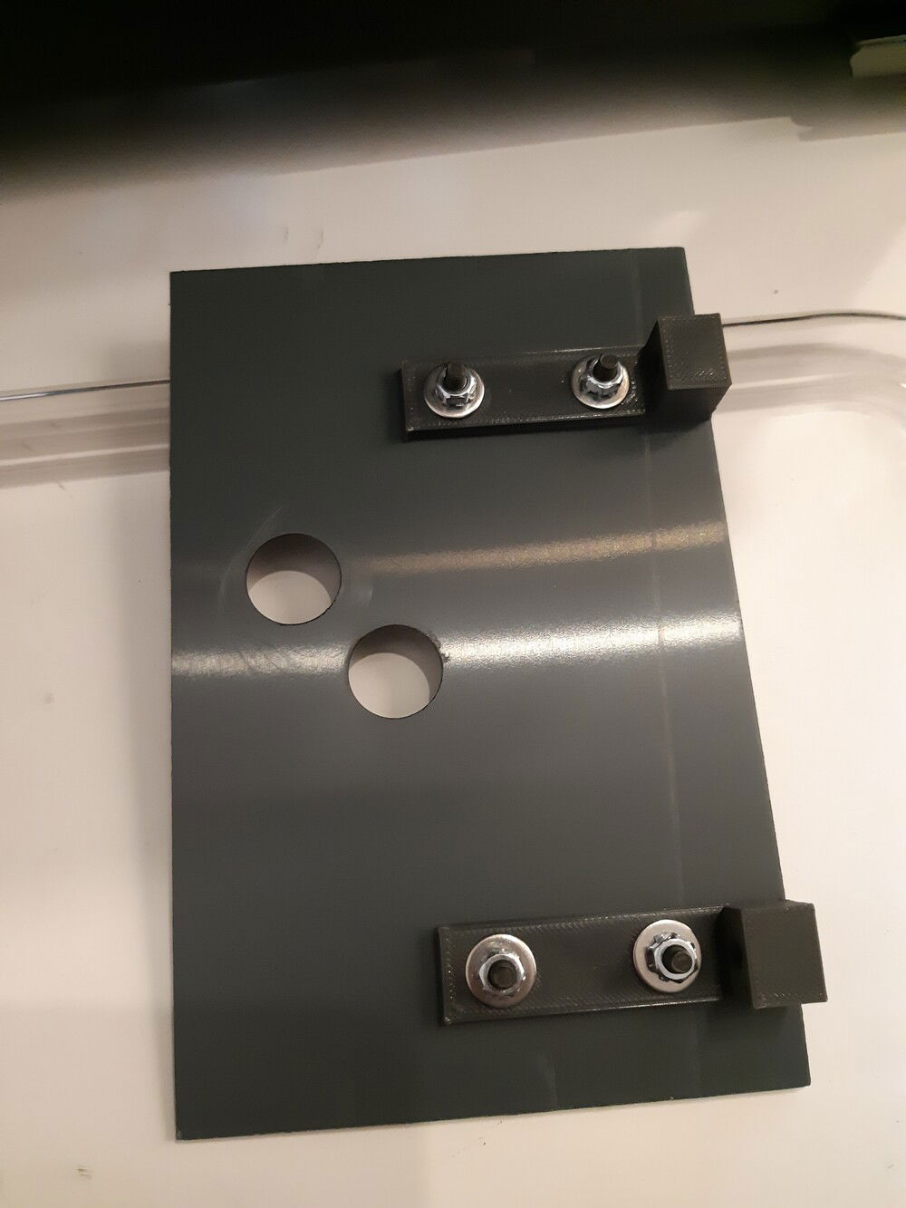 Lid of the Pump/PSU compartment, cut out of a 2 mm PVC sheet. 
On one side, I used two 3D printed L-brackets in order to fix it to the front panel.