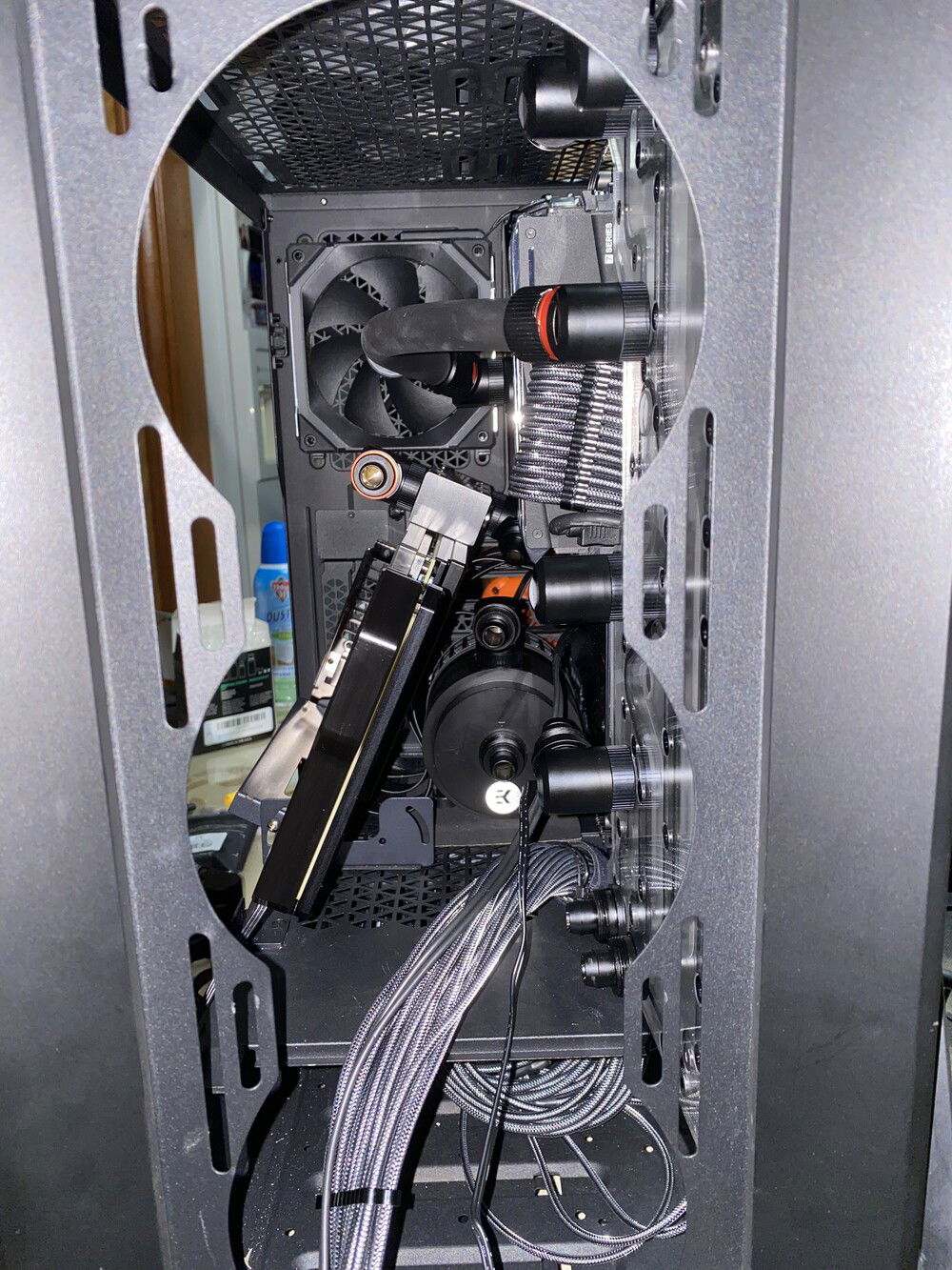 A shot through the front of the case w/ GPU installed. 

The multi angle gpu bracket works well with the Strix block since it’s fairly light. This was not possible with the Optimus block due to its weight and I had to keep it upright as the mount’s legs would not fit flush against the case. 

You can also see how much space there is between the GPU and the pump which made this stealth look possible!