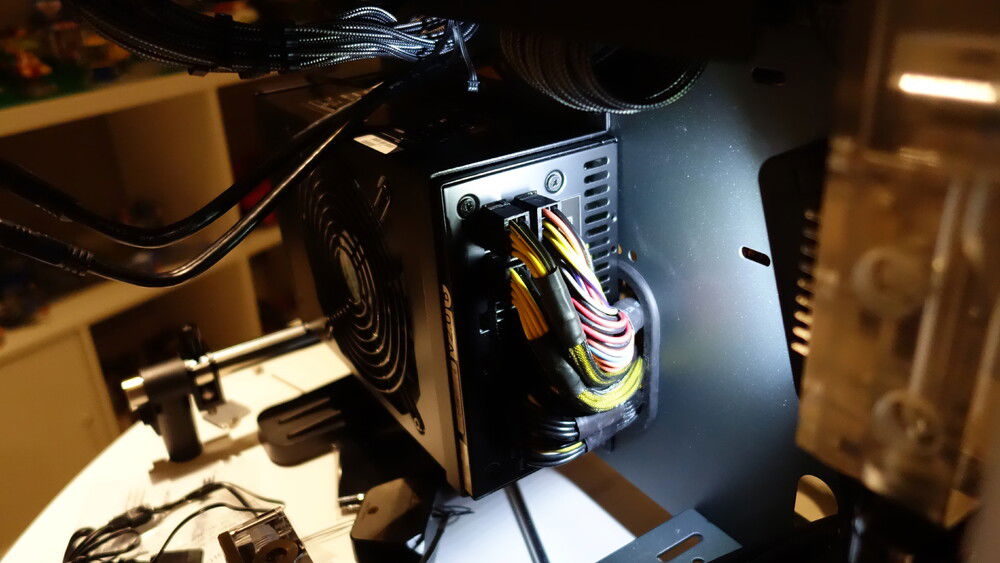 I kept the Silverstone Strider 1500W from my previous rig knowing it was too long for the P5. Solved it by reversing the mount, with just enough room left to route the cables through the cutout. Now if only i had access to a 3D printer to make a shroud....