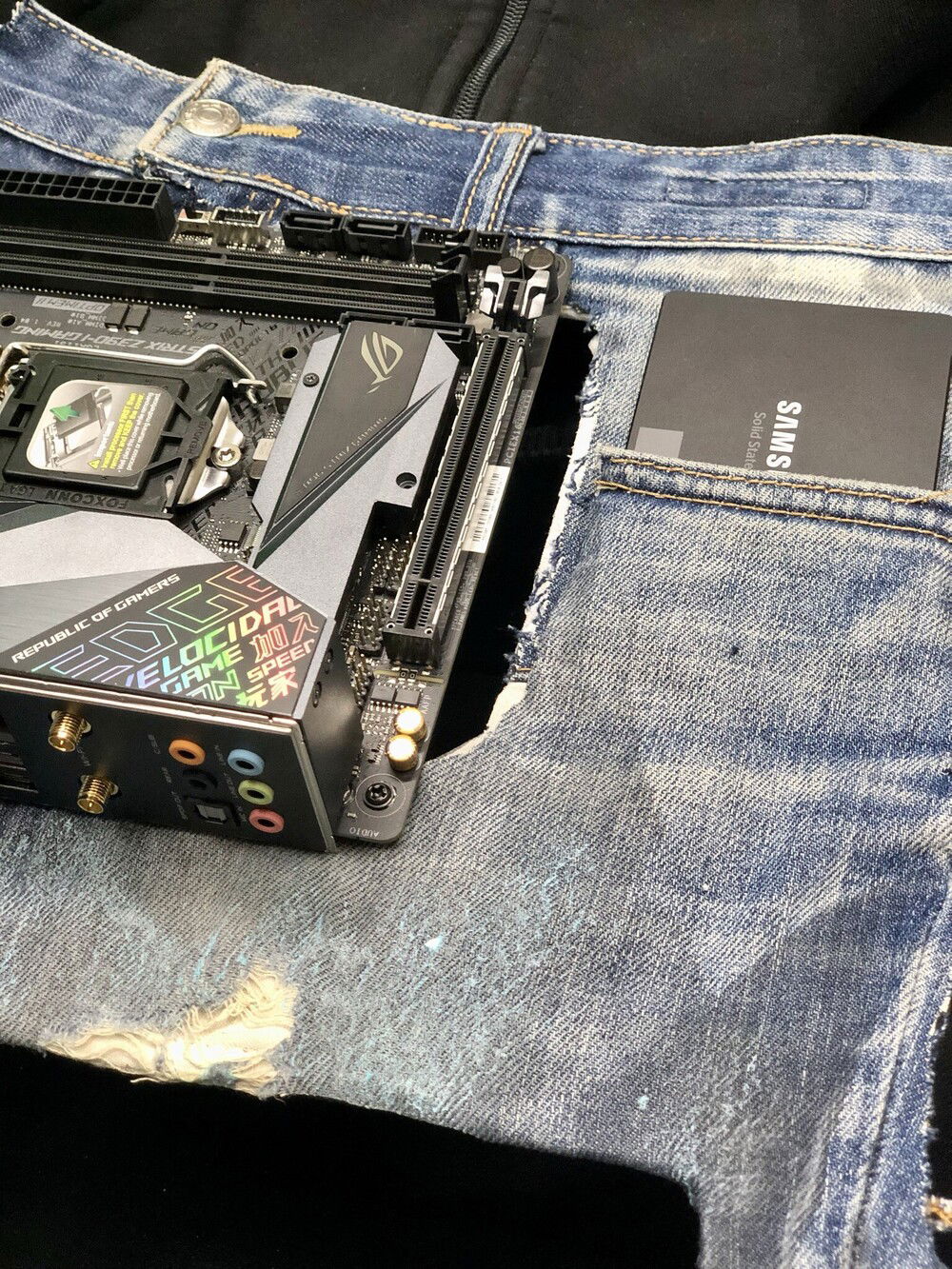 Testing an Asus ROG Strix Z390 motherboard on the covered panel of Antec Striker to fit a Samsung SSD on the pocket of the denim used.