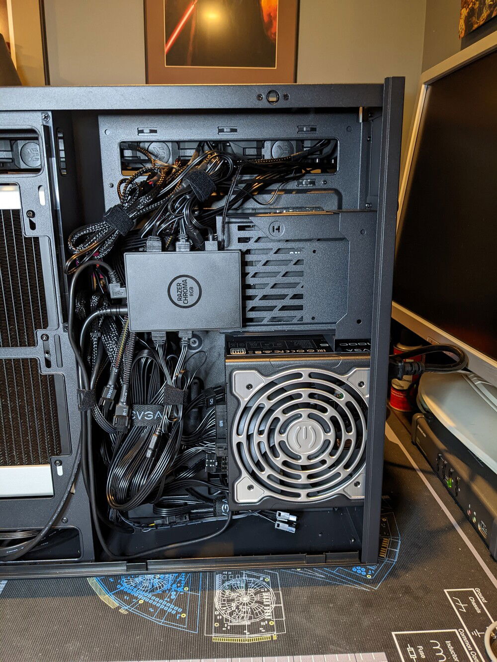 The ugly wiring mess. I'd intended to mount the Chroma controller into the bay itself, but the ARGB headers stick out too far on each side to allow this. So I'm using two screws here on the far end of the drive bay to hold the end of the controller. There wasn't a good place to use the double-sided tape. I considered the bottom of the case, but I don't think there would have been enough space there either.