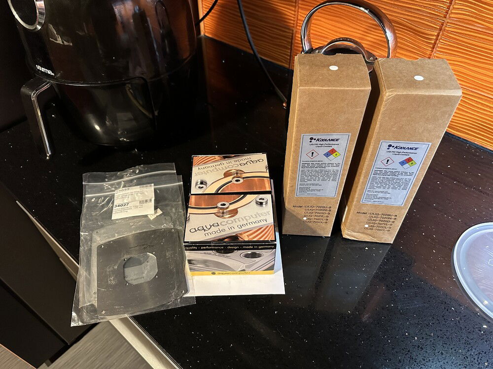 Another shipment of stuff. Two Aquacomputer filters, 120mm adapters for the filters, and two more bottles of clear Koolance 702.