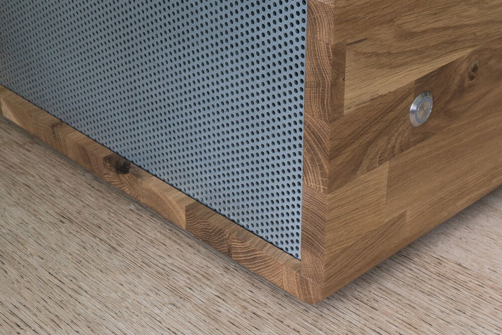 The aluminium mesh on either side allows for unobstructed air intake and exhaust. The mesh is held tightly in place in narrow grooves cut into the wood before assembly.