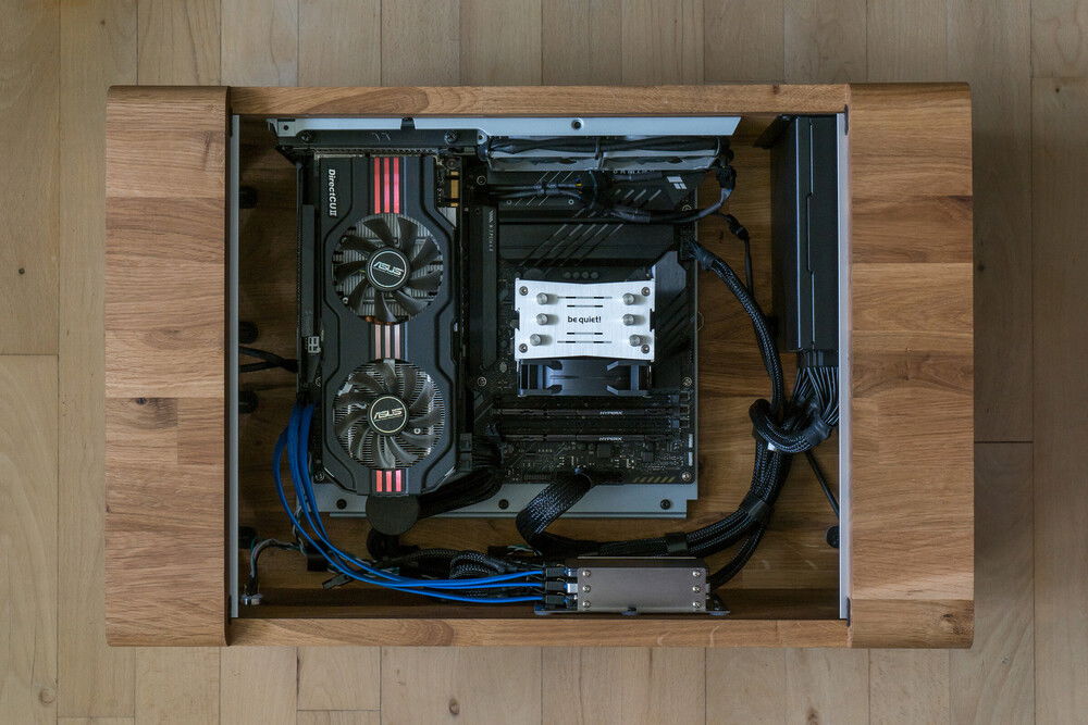 A top view of the inside. The picture is from just after I finished the build and shows my old GTX 560 GPU (due to the GPU-shortage in the beginning of the 2020's). The GPU is placed in a vertical mount (here functioning as a horizontal mount) and is connected using a riser cable. The GPU is held up by a height-adjustable support leg.