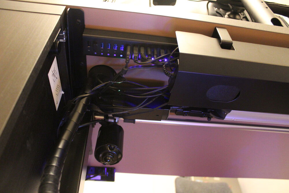 All USB devices are connected through the 13-port USB hub. Two tubes of cables come down from the desk, one on each side.