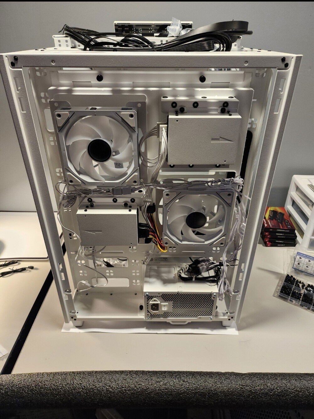 Back view of the tower's case fans and cables. 2 ssd drives are installed in each of the bays next to the fans, 4 total.