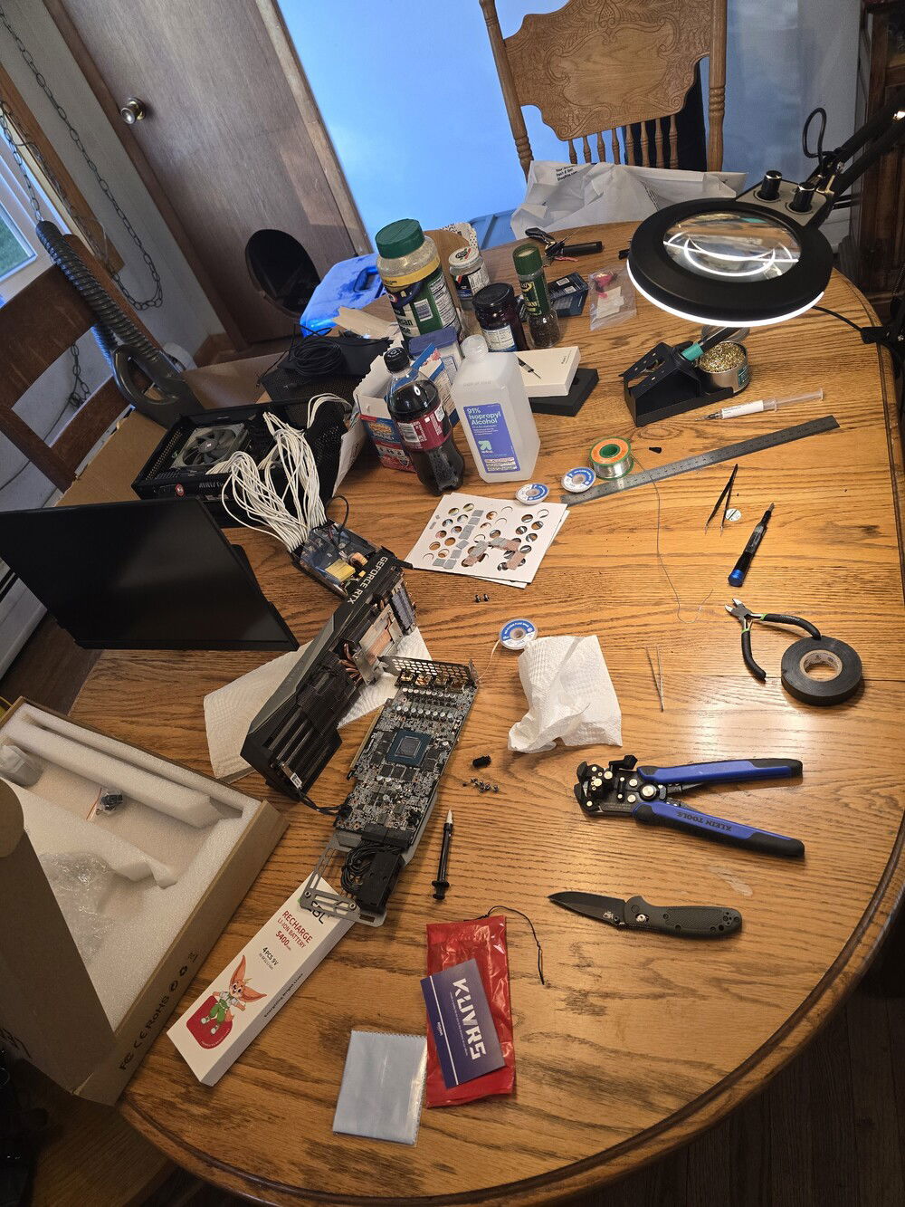 Dining table turned workshop. You can see the PSU opened up to remove the aforementioned fan mod. I kept it plugged into the mobo so it would drain it's caps so I didn't die lol. Sponsored by Kraft Parmesan, keep it cheesy.