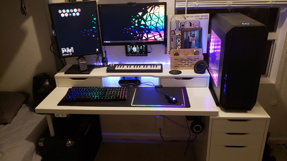 Full desk: two monitors, MIDI keyboard, Line 6 UX1, wooden stand on the right hides all the cables inside it. The lights behind the desk are synced with the motherboard and GPU.