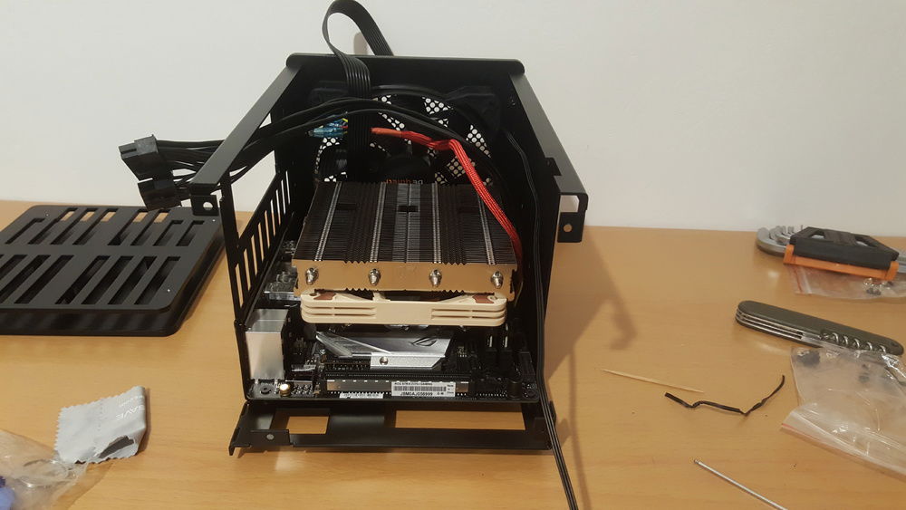 Fitting the motherboard into the frame. It was so tight I was concerned I might snap or break parts while fitting it in. The 24 pin cable protruded from edge of the motherboard and had to be sanded down slightly, even after that, it was still a major issue but I went ahead and fitted it anyways. After the first time I finished this step, I realised that the grounding flaps on the I/O was stuck inside the USB 3.0 port, making it unusable, so I had to go through the painful process of taking everything out again. This was after I had installed, screwed, and cabled the GPU and PSU. Unsurprising, my morale was at an all time low.