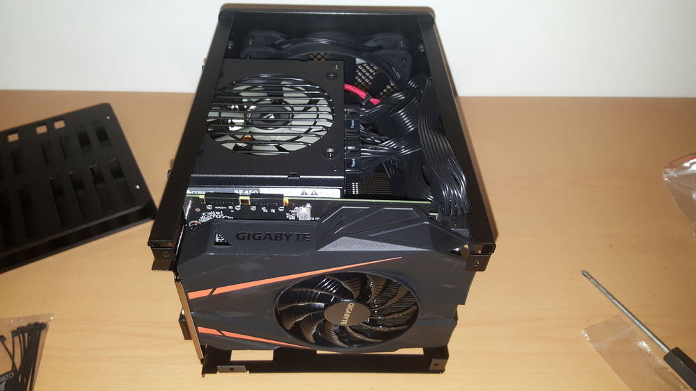 GPU and PSU fitted, cable space is very tight. Both the PSU and the bundle of cables are crammed directly above the CPU heat-sink which may affect thermals. Had to have several attempts at fitting the GPU in correctly because the tab wasn't perfectly aligned with the slot in the frame, in the end I just used a little force and hopefully the aluminium has enough give to not damage anything.