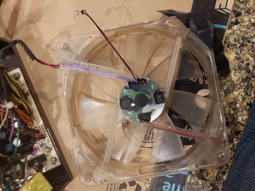PSU fan LED before modification. It would shine in my face while trying to sleep. The wires won't reach to the other side (top right).