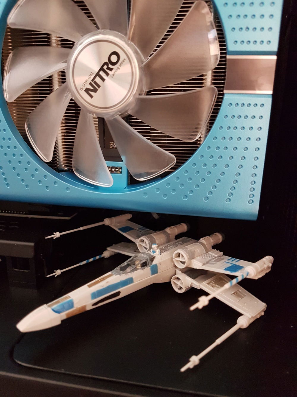 A close-up of the custom painted X-Wing Rebel Fighter. The color palette was change to match the sapphire blue of the case!