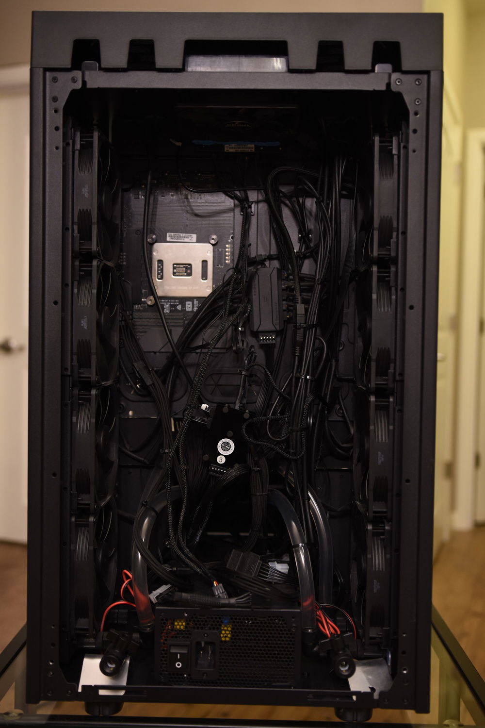 Rear of computer. The way this case works, there is not much surface area to mount cables to for proper cable management. Also, with the fans on the inside, I have to keep cables way from them or they may be sucked in. So it ends up looking like a mess. At least it is not visible.